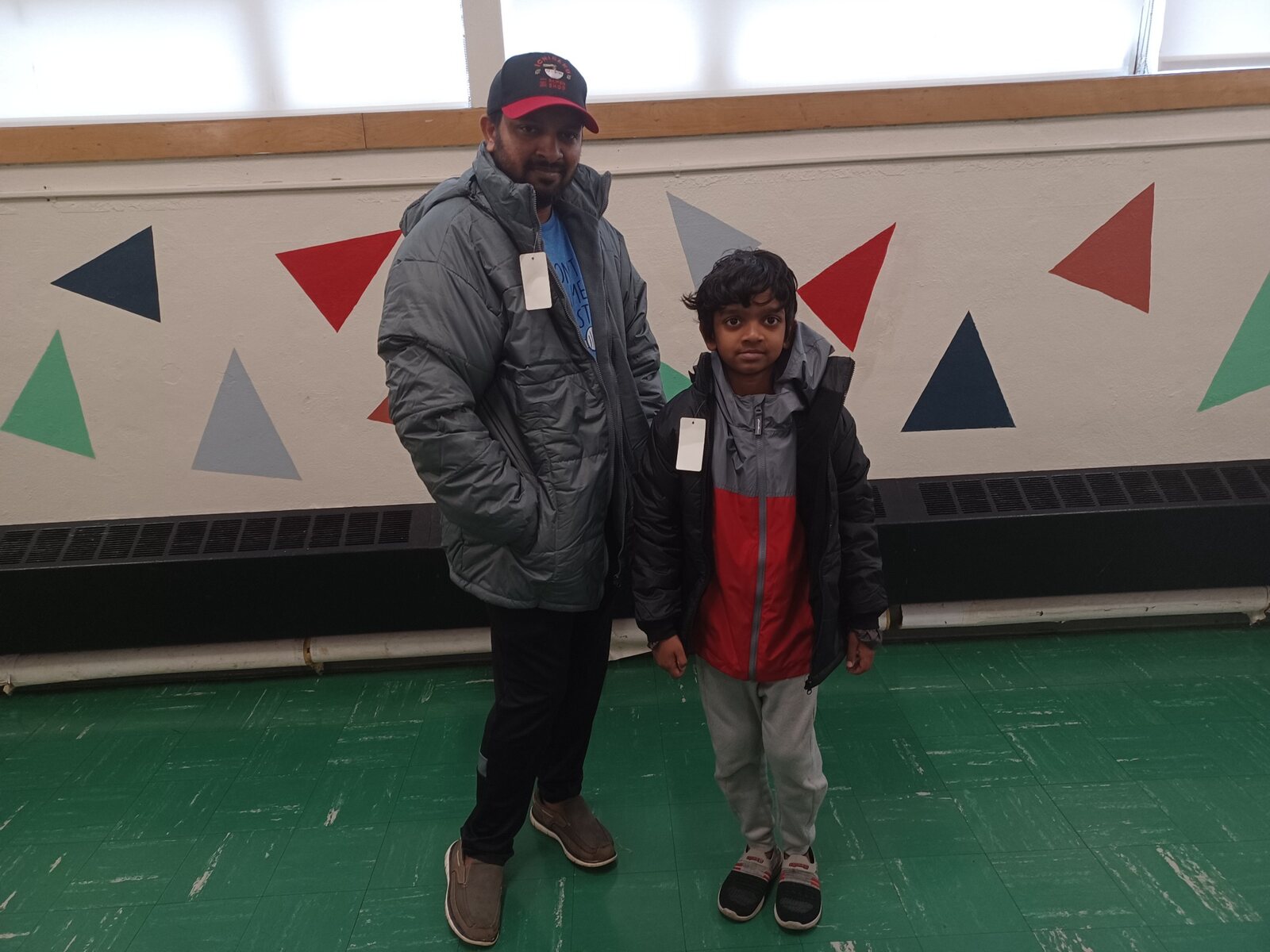 A father and son receiving winter coats at a SCRIP community coat drive