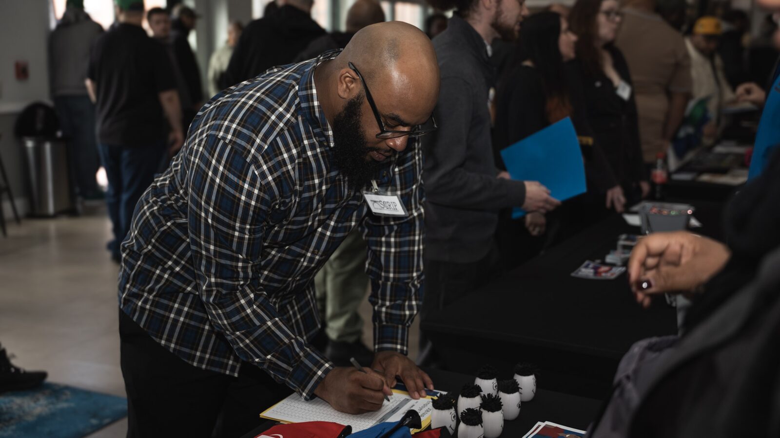 A community member signing materials during a SCRIP gathering