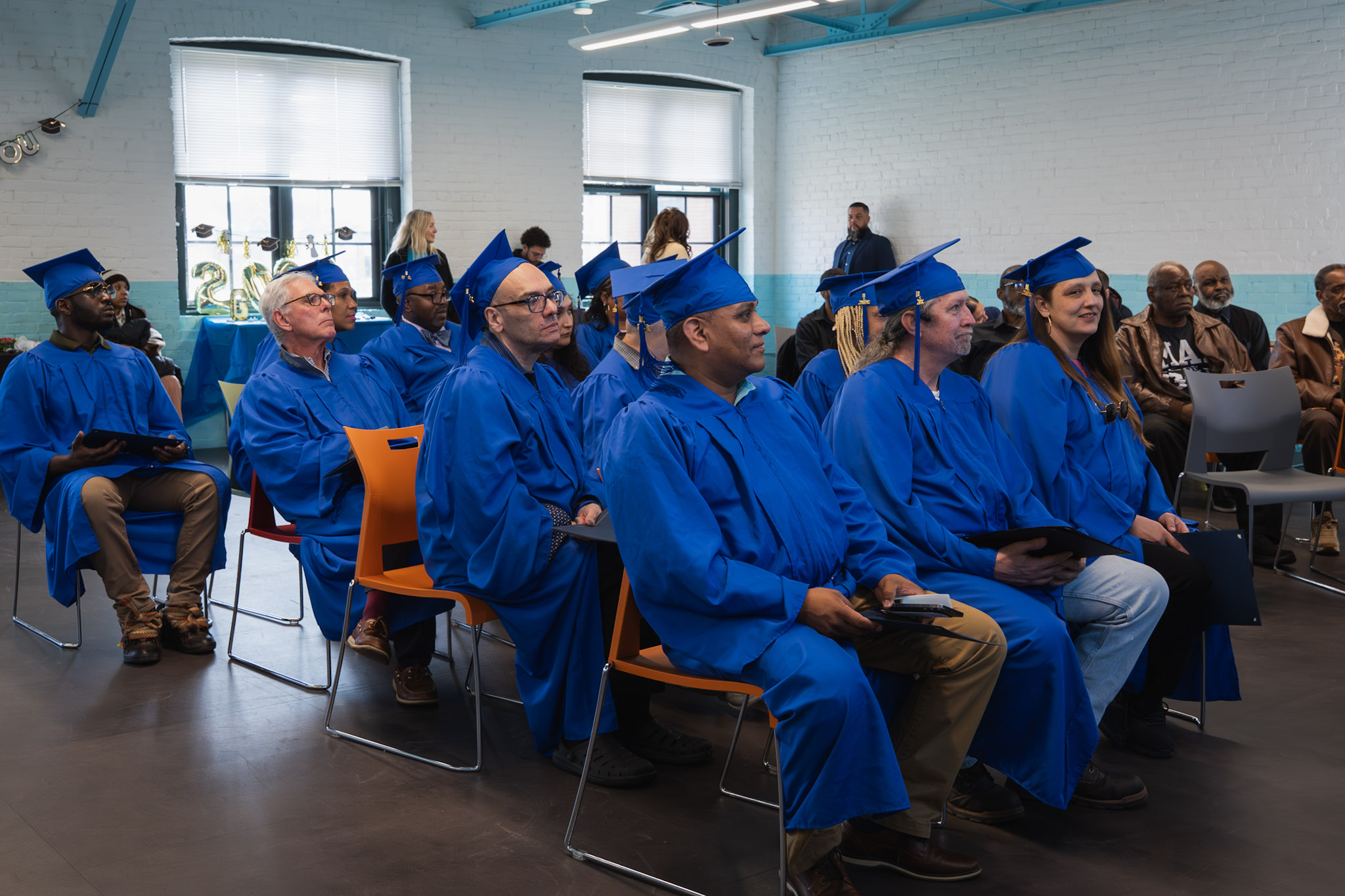 ASCEND graduates seated together in blue graduation attire