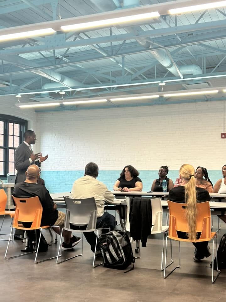 Participants and facilitators gathered around tables during a SCRIP program session