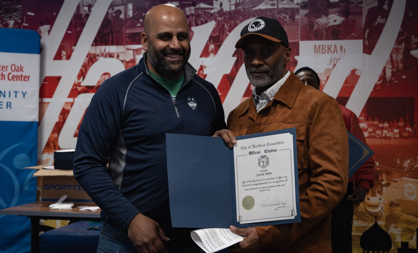 Hartford Mayor Arunan Arulampalam presenting Gerald Prince Miller with an official citation