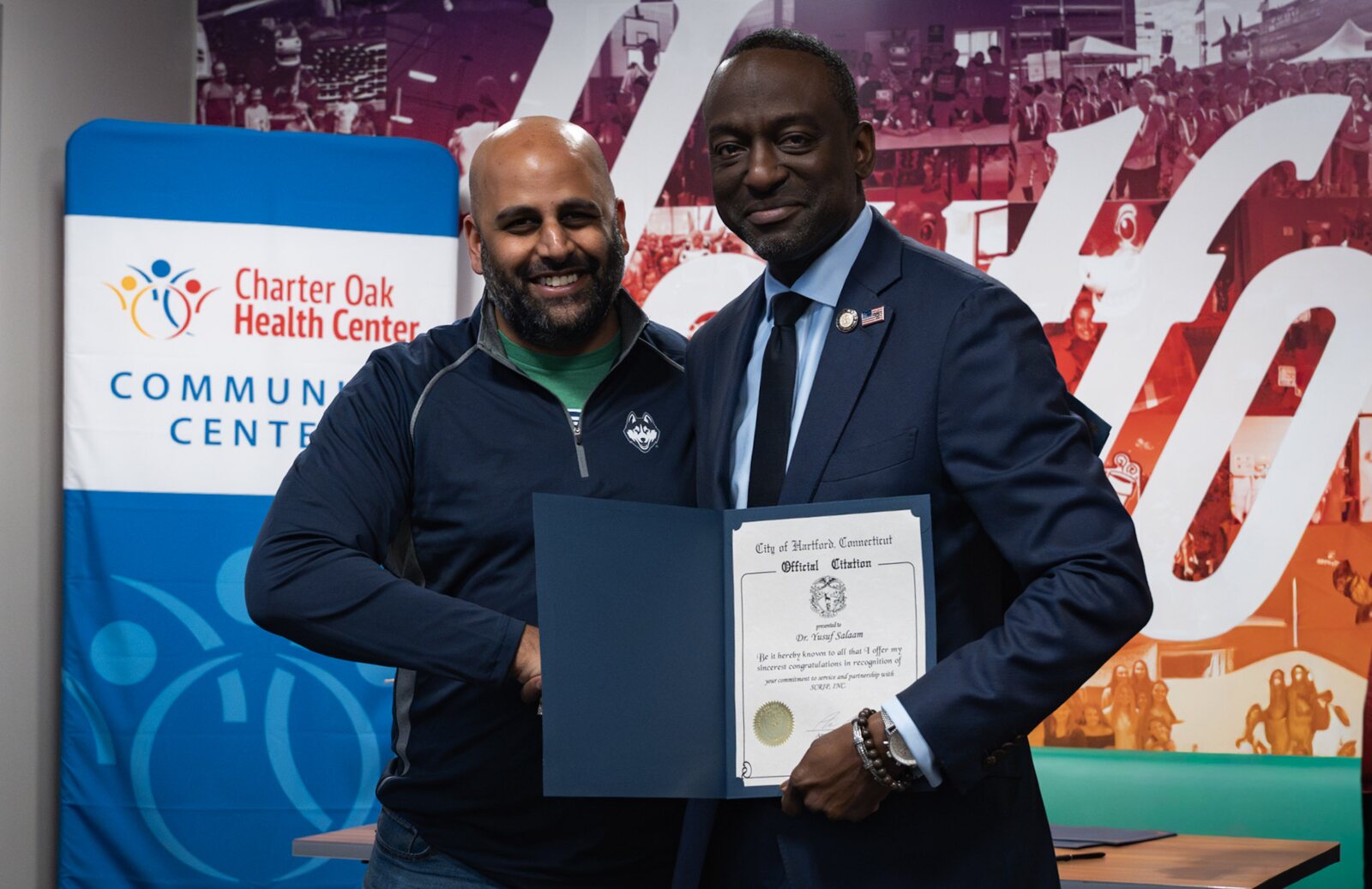 Hartford Mayor Arunan Arulampalam presenting Dr. Yusef Salaam with an official citation
